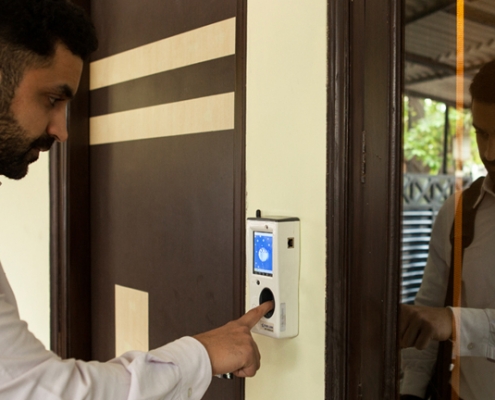 employee using biometric attendance scaner